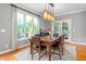 Sunlit dining area with large windows, a wood table, and stylish pendant lighting at 429 Carolina Cir, Durham, NC 27707