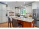 Bright kitchen featuring a granite island, custom cabinets, and stainless steel appliances at 429 Carolina Cir, Durham, NC 27707