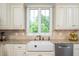 Kitchen showcasing a farmhouse sink, tile backsplash, and ample cabinet space at 429 Carolina Cir, Durham, NC 27707