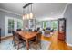 Well-lit living room flowing into the dining area, featuring hardwood floors and a neutral color palette at 429 Carolina Cir, Durham, NC 27707
