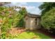 Charming backyard storage shed with wood siding, window, and landscaping at 429 Carolina Cir, Durham, NC 27707