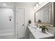Well-lit bathroom featuring a modern vanity with marble countertop and a tiled shower with a recessed shelf at 4301 Azalea Dr, Raleigh, NC 27612