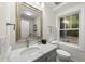 Bright bathroom featuring a vanity with quartz countertop, a framed mirror, and a window with a woodsy view at 4301 Azalea Dr, Raleigh, NC 27612