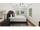Comfortable bedroom features a ceiling fan, plush bed with decorative pillows, and natural light from the windows at 4301 Azalea Dr, Raleigh, NC 27612