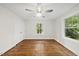 Spacious bedroom featuring a ceiling fan, hardwood floors, and a large window that offers a tranquil outdoor view at 4301 Azalea Dr, Raleigh, NC 27612