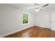 Empty bedroom with hardwood floors, a ceiling fan, and a bright window and ensuite access at 4301 Azalea Dr, Raleigh, NC 27612