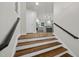 Warm entryway with hardwood stairs leading to a bright, open-concept kitchen at 4301 Azalea Dr, Raleigh, NC 27612