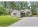 Home featuring a detached garage and a concrete driveway, surrounded by mature trees at 4301 Azalea Dr, Raleigh, NC 27612