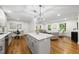 Open-concept kitchen with island, dining area, and living space, featuring hardwood floors and stylish lighting at 4301 Azalea Dr, Raleigh, NC 27612