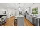 Open-concept kitchen featuring an island with seating, stainless appliances, and hardwood flooring at 4301 Azalea Dr, Raleigh, NC 27612