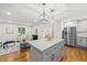 Spacious kitchen includes a large island, stainless steel appliances, and opens to the living room with hardwood floors at 4301 Azalea Dr, Raleigh, NC 27612