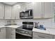 Modern kitchen boasts stainless steel appliances, white cabinets, and sleek countertops for cooking and entertaining at 4301 Azalea Dr, Raleigh, NC 27612