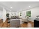 Bright living room featuring hardwood floors, neutral decor, and large windows with green views at 4301 Azalea Dr, Raleigh, NC 27612