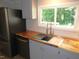 Bright kitchen with stainless steel appliances, butcher block counters, and a window overlooking the backyard greenery at 440 Montgomery Rd, Franklinton, NC 27525