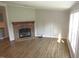 Inviting living room featuring a stone fireplace, wood-look floors, and natural light from the nearby windows at 440 Montgomery Rd, Franklinton, NC 27525