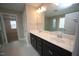 Bathroom boasting a double sink vanity with white countertop, dark wood cabinets, and tile flooring at 4416 Walker Hallow St, Raleigh, NC 27616