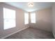 Cozy bedroom featuring three bright windows, neutral walls, and wood-look flooring at 4416 Walker Hallow St, Raleigh, NC 27616