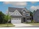 Charming two-story home featuring stone accents, a two-car garage, and a well-maintained lawn at 4416 Walker Hallow St, Raleigh, NC 27616