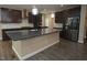 Modern kitchen with dark cabinets, granite countertops, and stainless steel appliances at 4416 Walker Hallow St, Raleigh, NC 27616