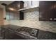 Gourmet kitchen featuring a gas cooktop, granite countertops, and stainless steel hood at 4416 Walker Hallow St, Raleigh, NC 27616