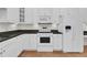 Bright kitchen with white cabinets, granite countertops, and modern appliances at 4622 Ludwell Branch Ct, Raleigh, NC 27612
