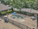 View of the splash pad area with tables, chairs, and fencing surrounded by trees and landscaping at 4622 Ludwell Branch Ct, Raleigh, NC 27612