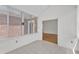 A sunroom with white painted brick and tile floor leads into a room with hardwood floors at 4622 Ludwell Branch Ct, Raleigh, NC 27612