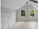 Bedroom with neutral colors, two windows, and light wood floors at 505 Hawfields Rd, Mebane, NC 27302