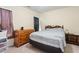 Well lit bedroom with a queen bed, dresser, and nightstand with side lamp at 5104 Parkerwood Dr, Knightdale, NC 27545