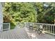 Back deck with outdoor seating and white railing overlooking the backyard and mature trees at 5509 Cliffwood Ct, Raleigh, NC 27609