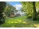 Spacious backyard with lush greenery, showcasing the home's exterior and surrounding mature trees at 5509 Cliffwood Ct, Raleigh, NC 27609