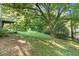 Lush backyard featuring a mature tree, with the deck of the home visible in the background at 5509 Cliffwood Ct, Raleigh, NC 27609