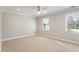 Spacious bedroom with large windows, carpet flooring, a ceiling fan, and neutral decor, perfect for relaxation at 5509 Cliffwood Ct, Raleigh, NC 27609