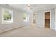 Bright bedroom featuring neutral carpet, large windows for natural light, ceiling fan and attached bath at 5509 Cliffwood Ct, Raleigh, NC 27609