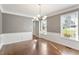 Dining room with wainscoting, hardwood floors, and natural light from large windows at 5509 Cliffwood Ct, Raleigh, NC 27609