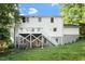 Two-story home's exterior with a white deck and staircase, set against a green, landscaped backdrop at 5509 Cliffwood Ct, Raleigh, NC 27609
