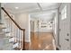 Inviting foyer with hardwood floors, staircase, white trim, and a view into the living room with built-in shelving at 5509 Cliffwood Ct, Raleigh, NC 27609