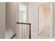 Upstairs hallway with a wooden banister, carpet, and doors leading to the bedrooms at 5509 Cliffwood Ct, Raleigh, NC 27609