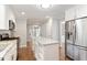 Bright kitchen features a center island, stainless steel refrigerator, and open design at 5509 Cliffwood Ct, Raleigh, NC 27609
