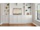 Built in shelving, cabinets and drawers with gold toned knobs and drawer pulls, view of a window and artwork at 5509 Cliffwood Ct, Raleigh, NC 27609