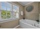 Bright bathroom with large window, garden tub, and decorative flower accent at 5515 South Roxboro # 32, Durham, NC 27713