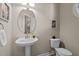 Stylish powder room featuring a pedestal sink, oval mirror, and decorative artwork at 5515 South Roxboro # 32, Durham, NC 27713
