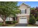 Charming exterior view of a two-story home with a stone facade, manicured landscaping, and attached garage at 5515 South Roxboro # 32, Durham, NC 27713