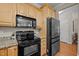 Bright kitchen features wood cabinets, granite countertops, and black appliances at 5515 South Roxboro # 32, Durham, NC 27713