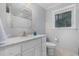 Bright bathroom features a marble countertop vanity, toilet, and window providing natural light at 5900 Holly Dr, Raleigh, NC 27616