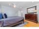 Spacious primary bedroom with calming color palette, ceiling fan, and dresser at 5900 Holly Dr, Raleigh, NC 27616