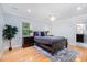 Sunlit primary bedroom boasts hardwood floors and neutral walls providing a calming atmosphere at 5900 Holly Dr, Raleigh, NC 27616