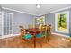Dining room with natural light, wooden table with upholstered chairs and hardwood floors at 5900 Holly Dr, Raleigh, NC 27616