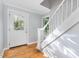 Bright entryway with hardwood floors, a decorative glass door, and staircase leading to the upper level at 5900 Holly Dr, Raleigh, NC 27616