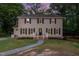 Two-story home boasts curb appeal with manicured lawn, walkway, and well-lit front porch at 5900 Holly Dr, Raleigh, NC 27616